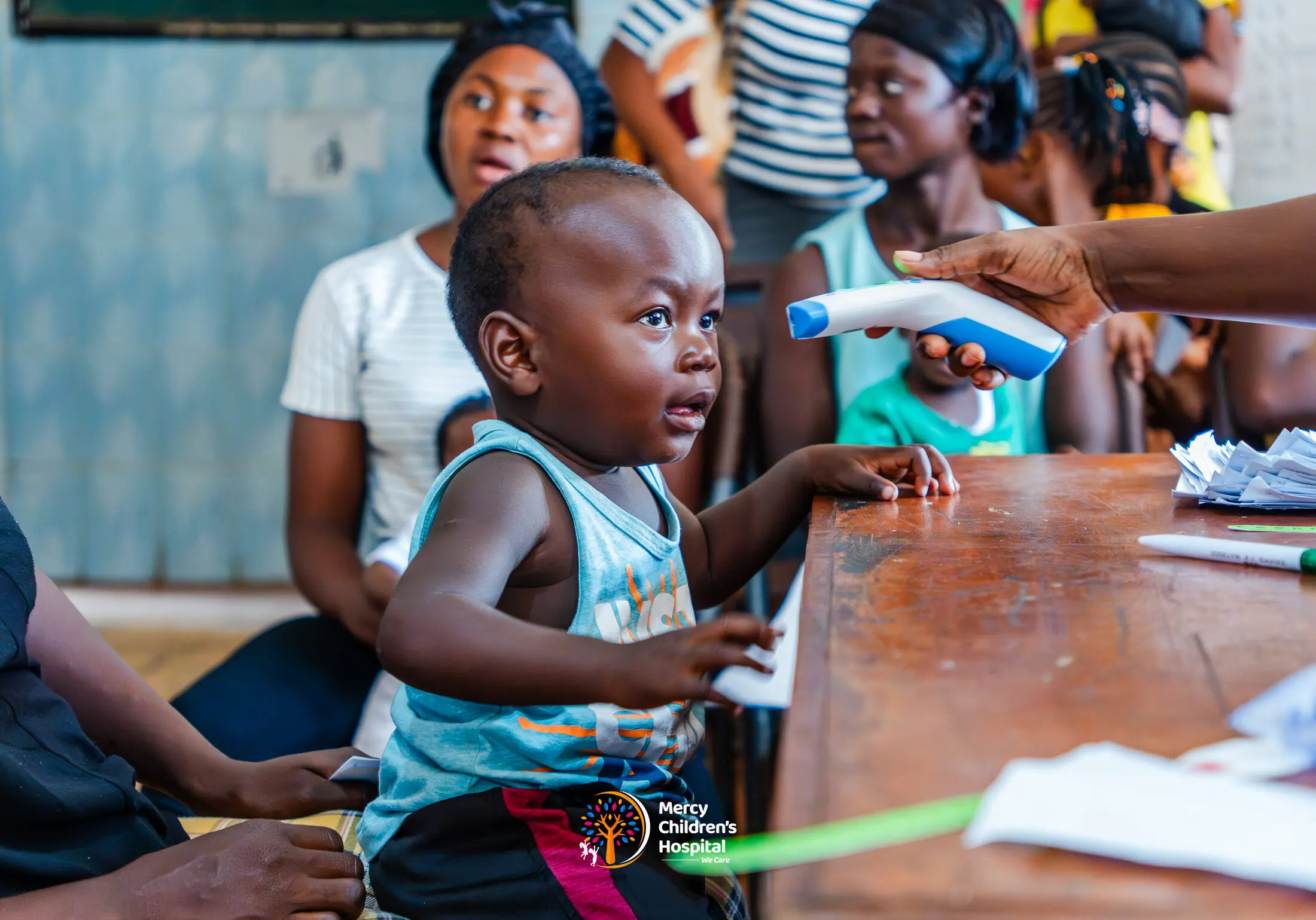 A health worker checking a young child's temperature